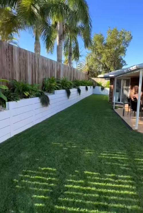 Landscaped backyard with a continuous raised garden edge