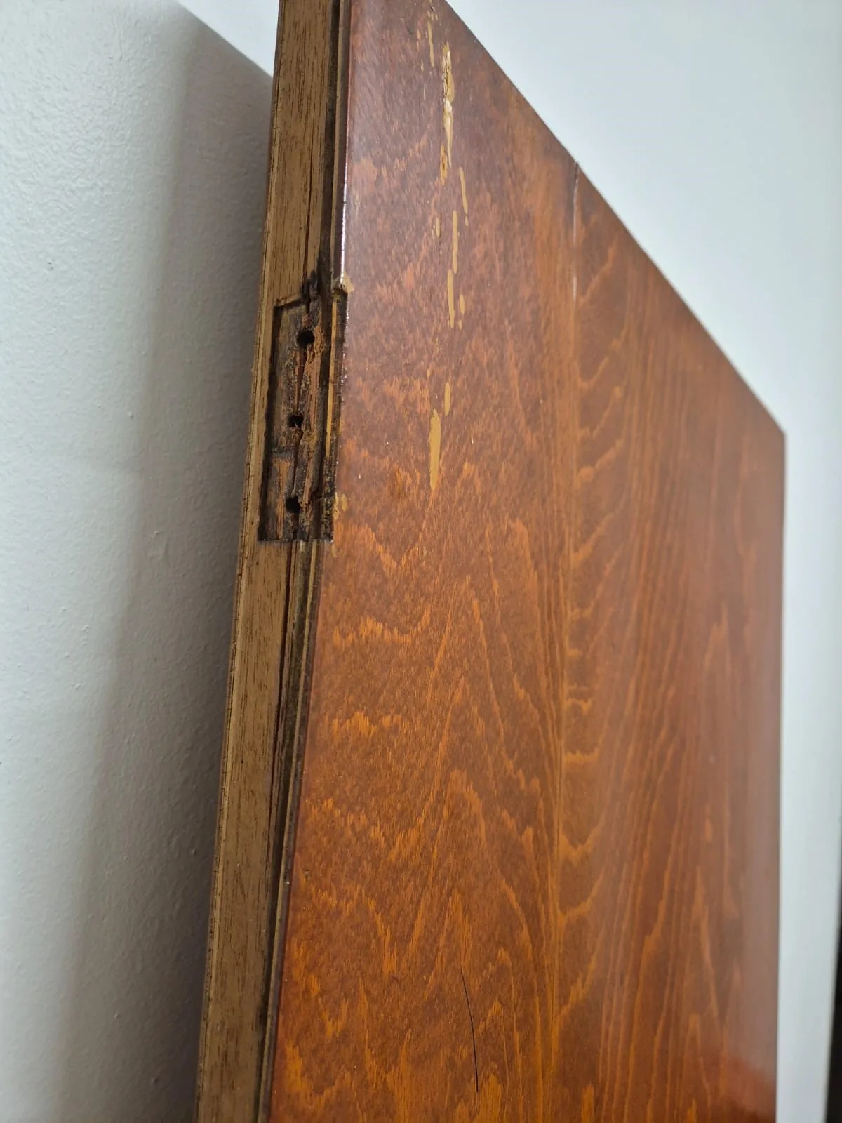 Damaged timber around a former hinge recess on a door edge